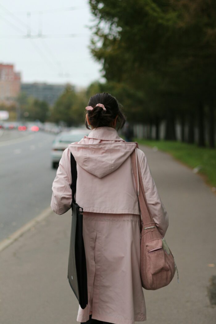 A woman walking on a sidewalk.
